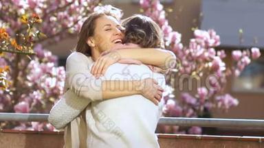 年轻女子在母亲节向年迈`母亲表示祝贺. 一个女人拥抱她的妈妈，微笑着对她说温柔的话